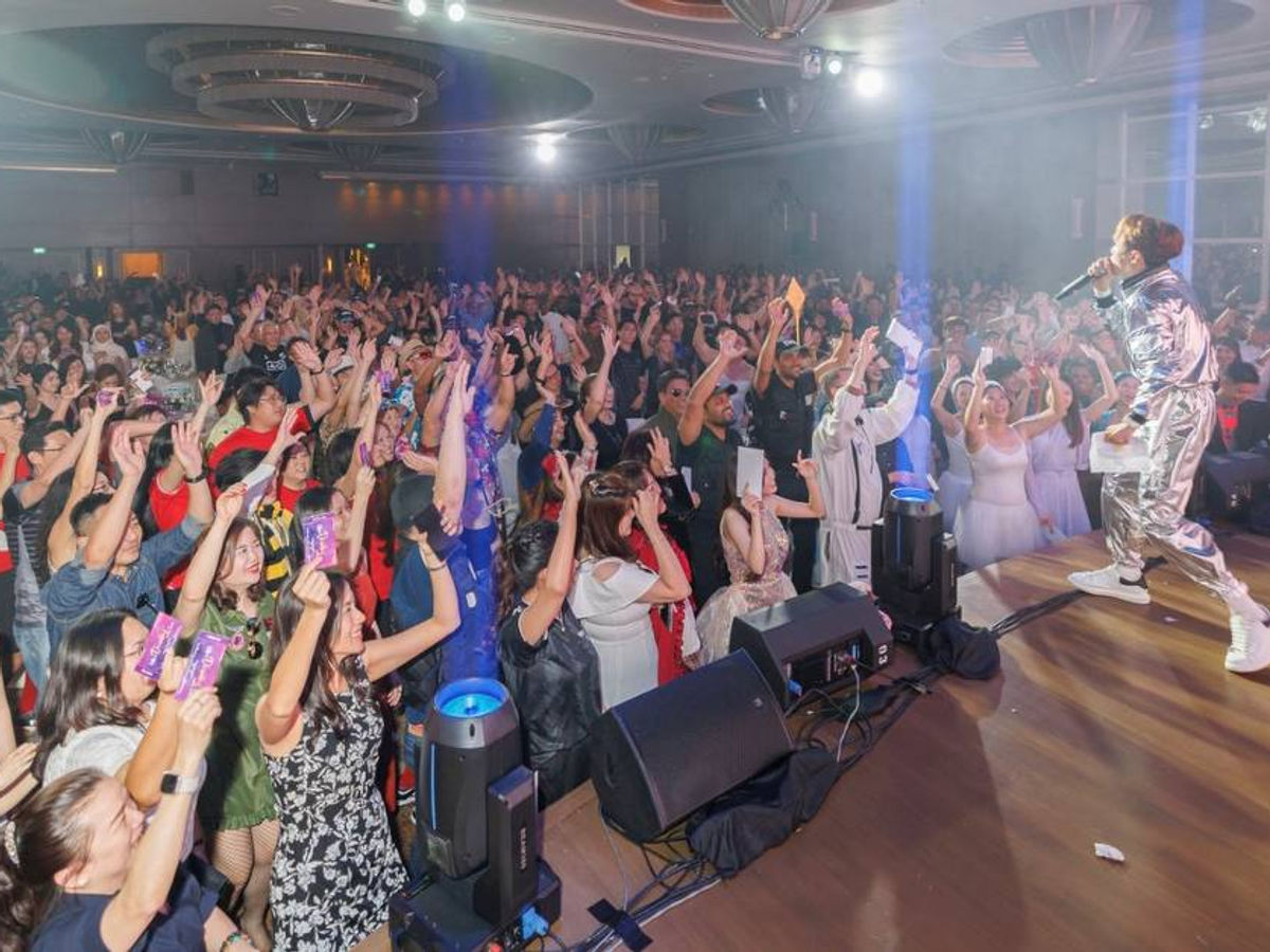 Jackie See hosting on stage at a corporate event
