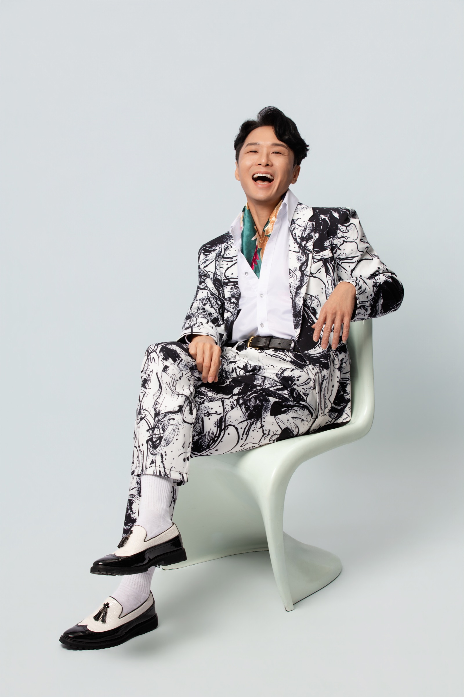 Jackie See laughing in a patterned black and white suit