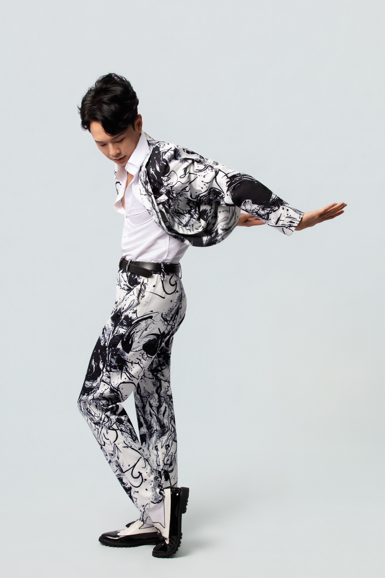 Jackie See throwing his jacket back in a black and white performance outfit